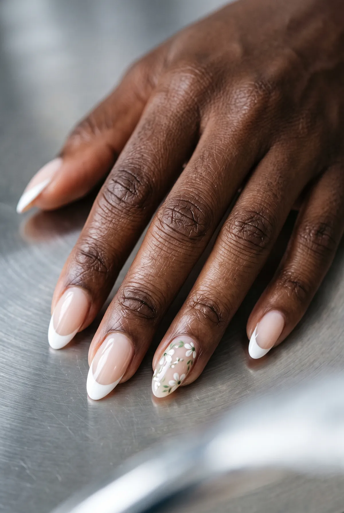 White French with Micro Florals — almond french nails with white french tips, plus tiny white-and-green floral art on one or two accent nails